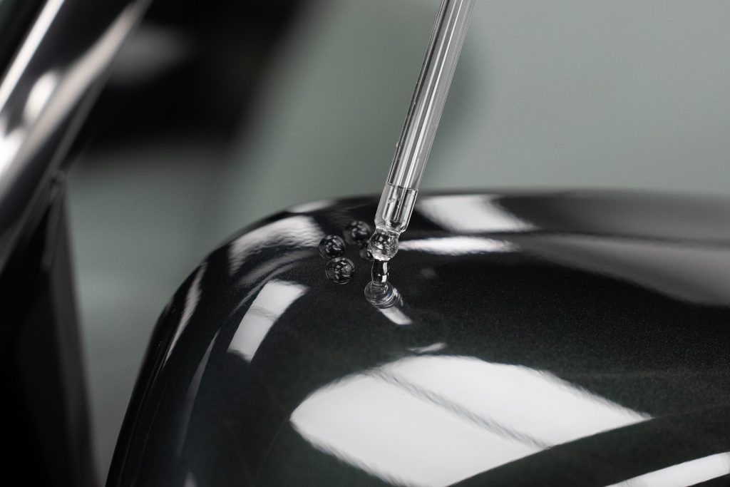 Ceramic coating being applied from a dropper onto green paintwork