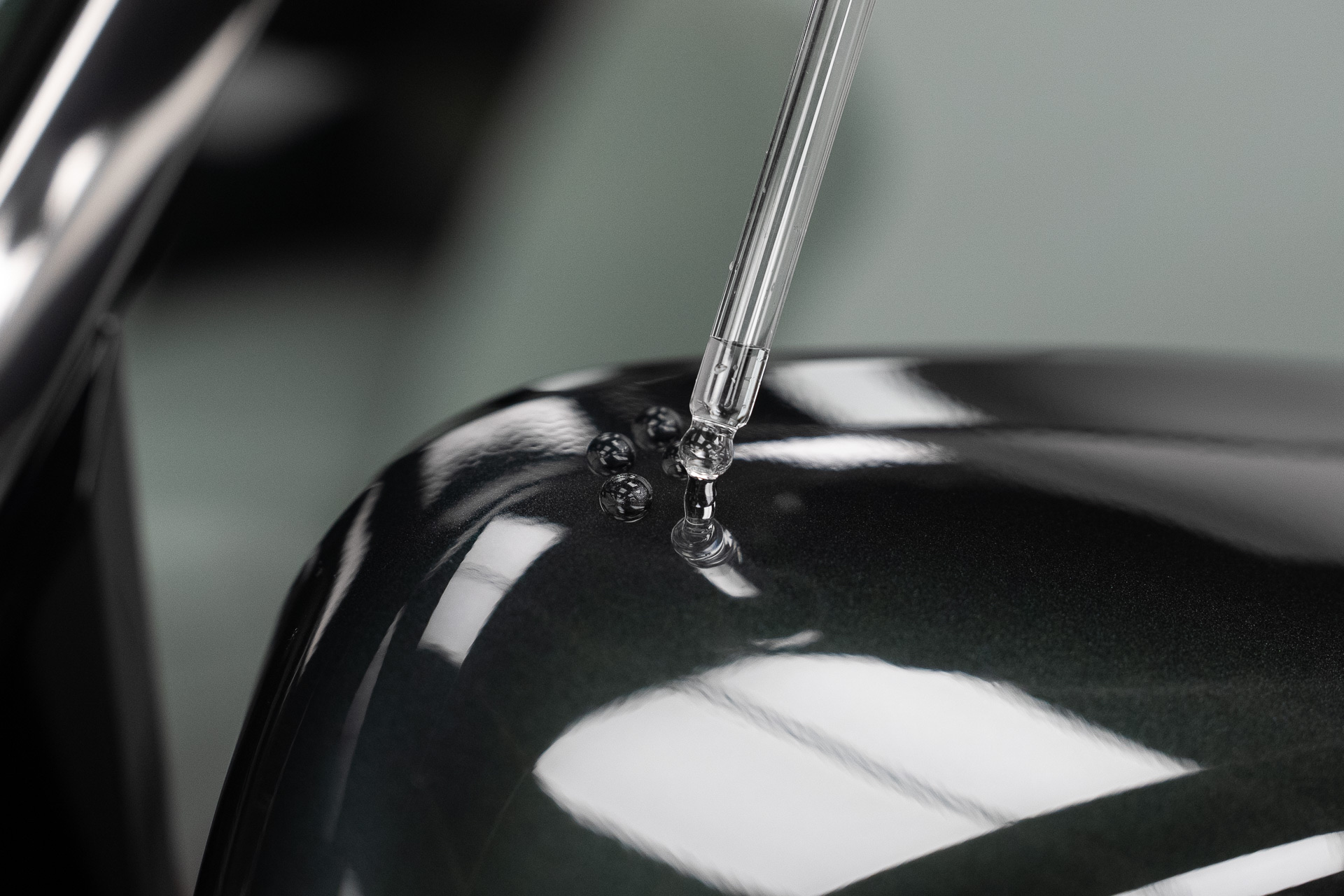 Ceramic coating being applied from a dropper onto green paintwork