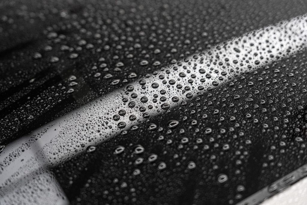 Tight water beading across a black ceramic coated panel