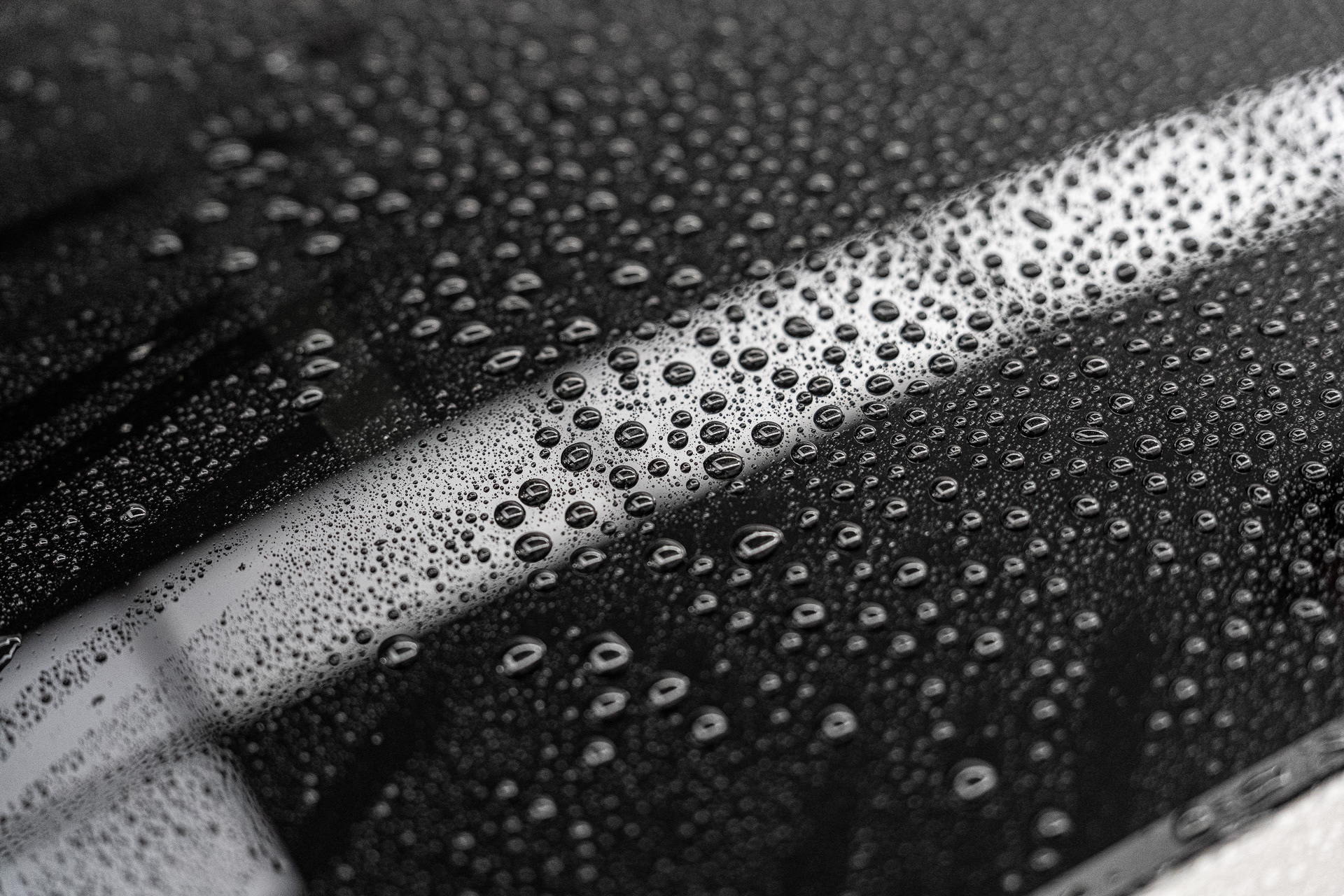 Tight water beading across a black ceramic coated panel