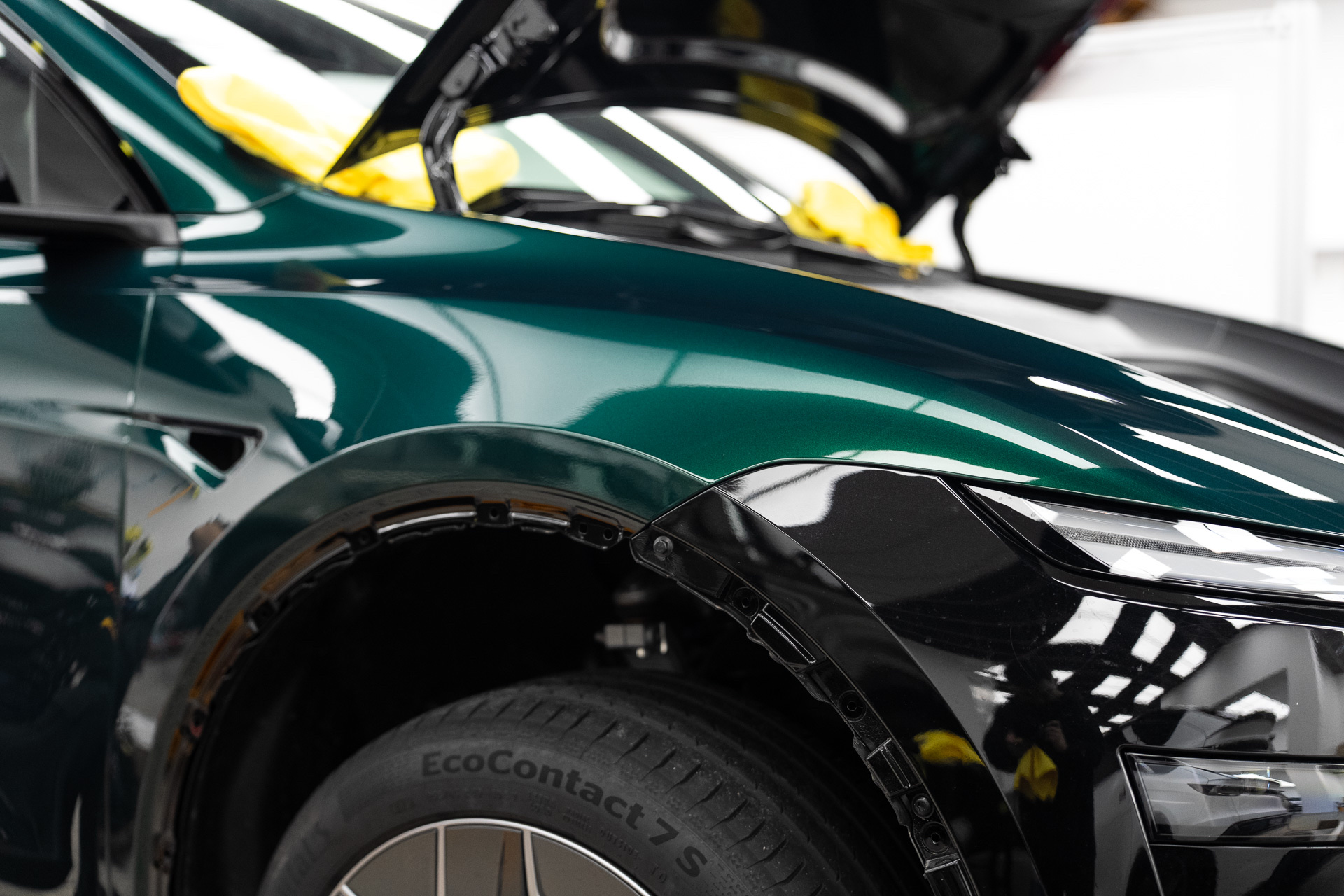 Dark green colour PPF on a wheel arch and bonnet edge