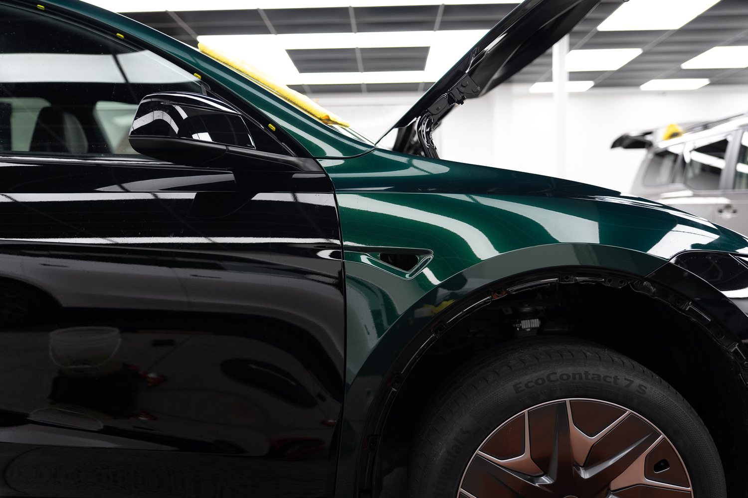 Dark green car with the bonnet up in the Liquid R workshop