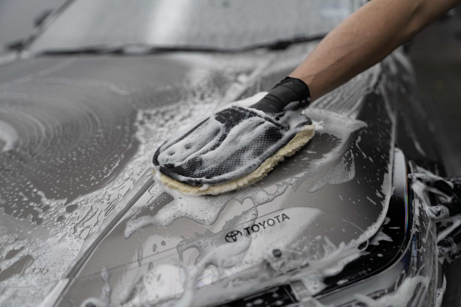 Wash mitt on a soapy Toyota bonnet