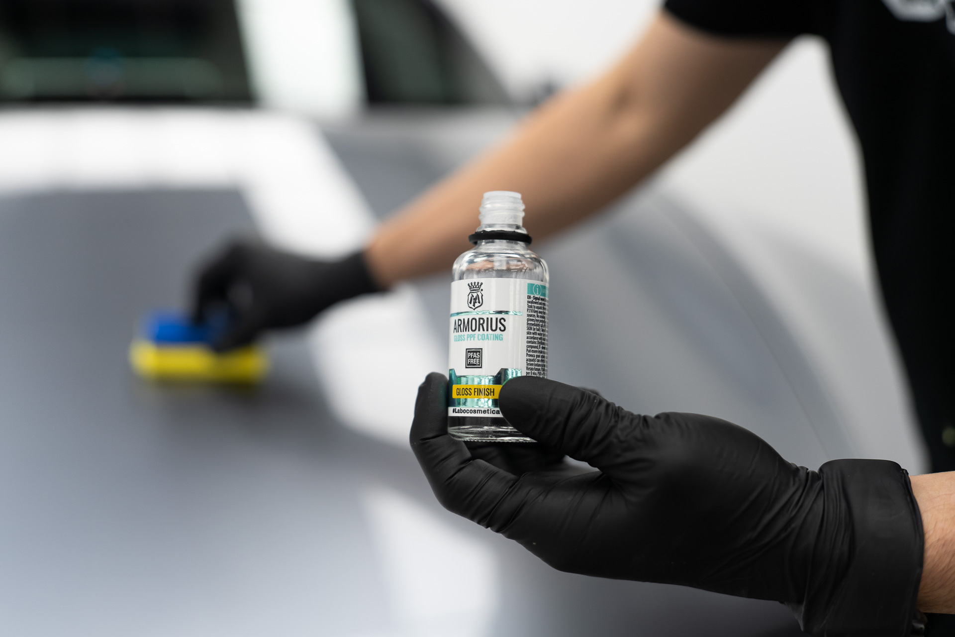 Applying Gtechniq coating with a yellow applicator on a silver panel