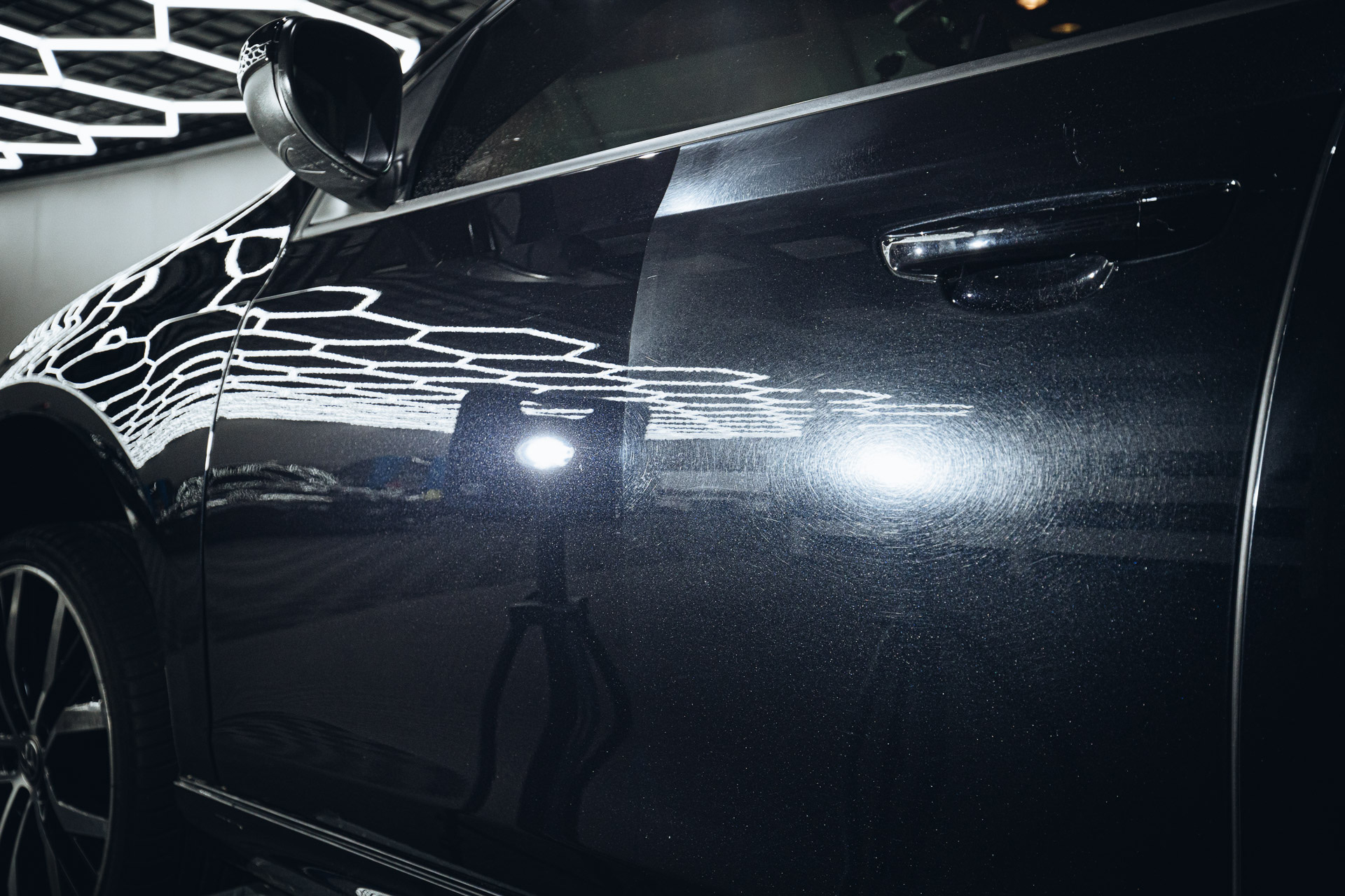 Black paintwork under inspection light showing gloss after correction
