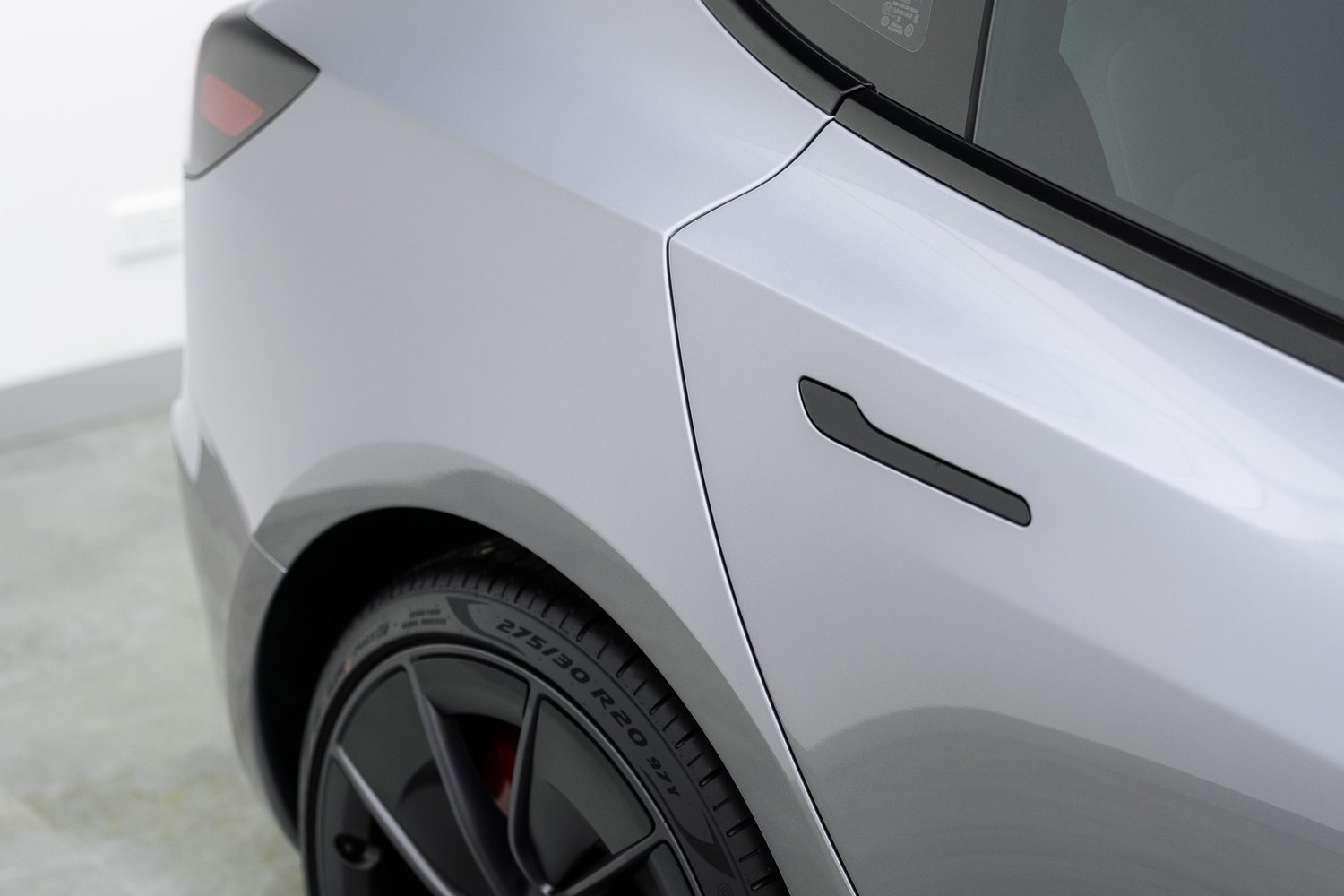 Door and mirror detail on a silver Tesla Model 3