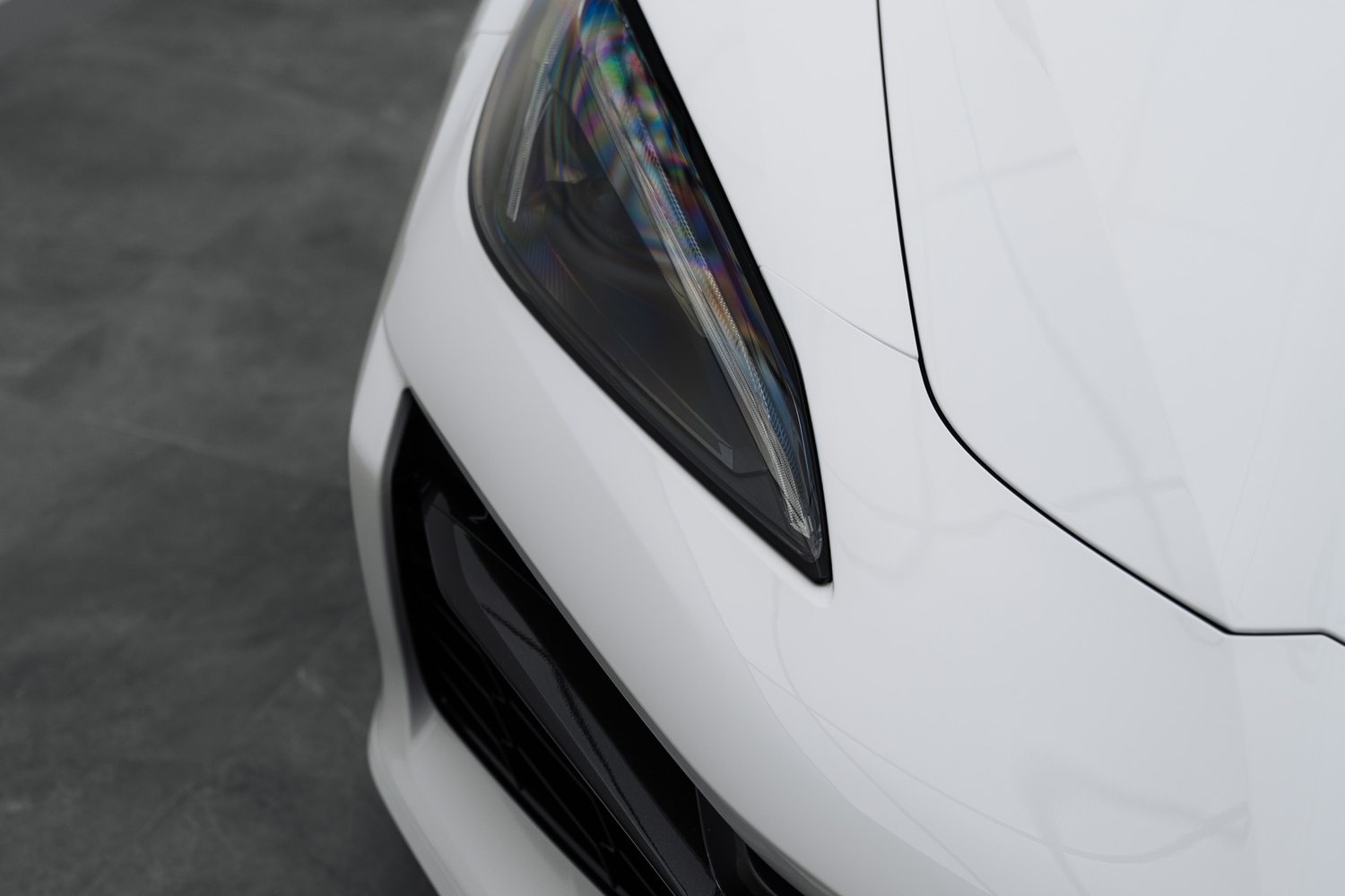 Headlight of a white Chevrolet Corvette