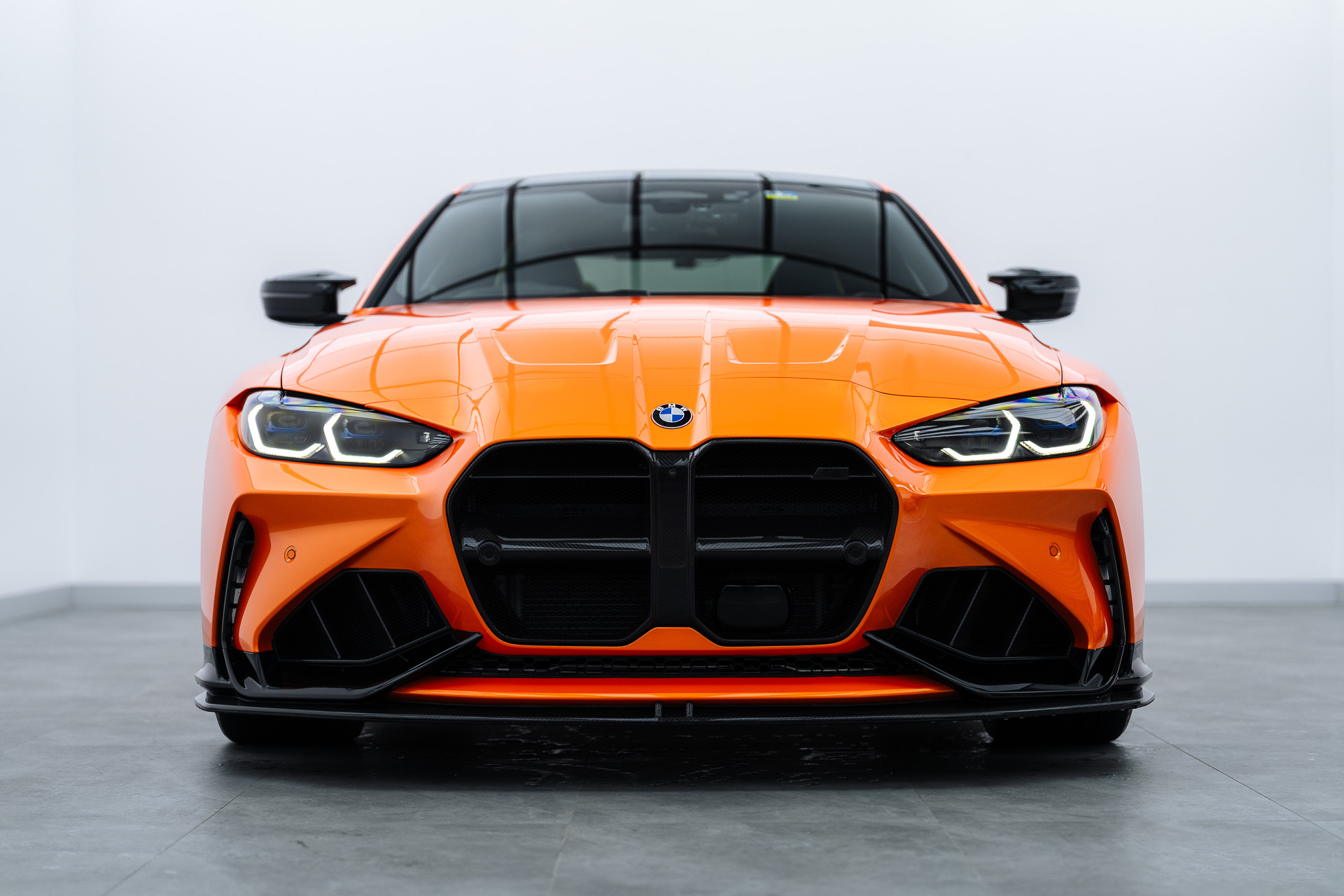 Orange BMW M4 front view in the Liquid R studio