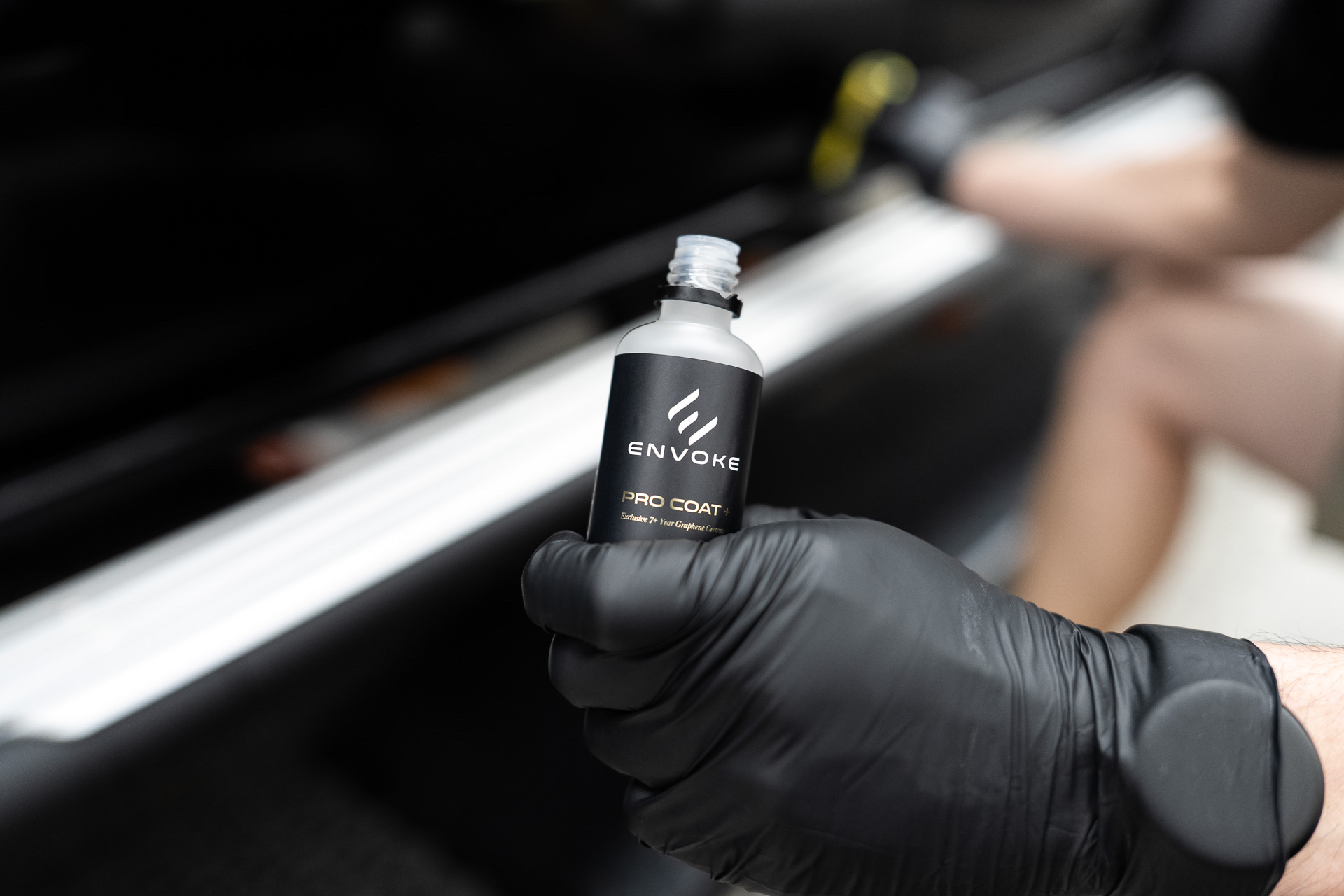 Technician holding an Envoke coating bottle