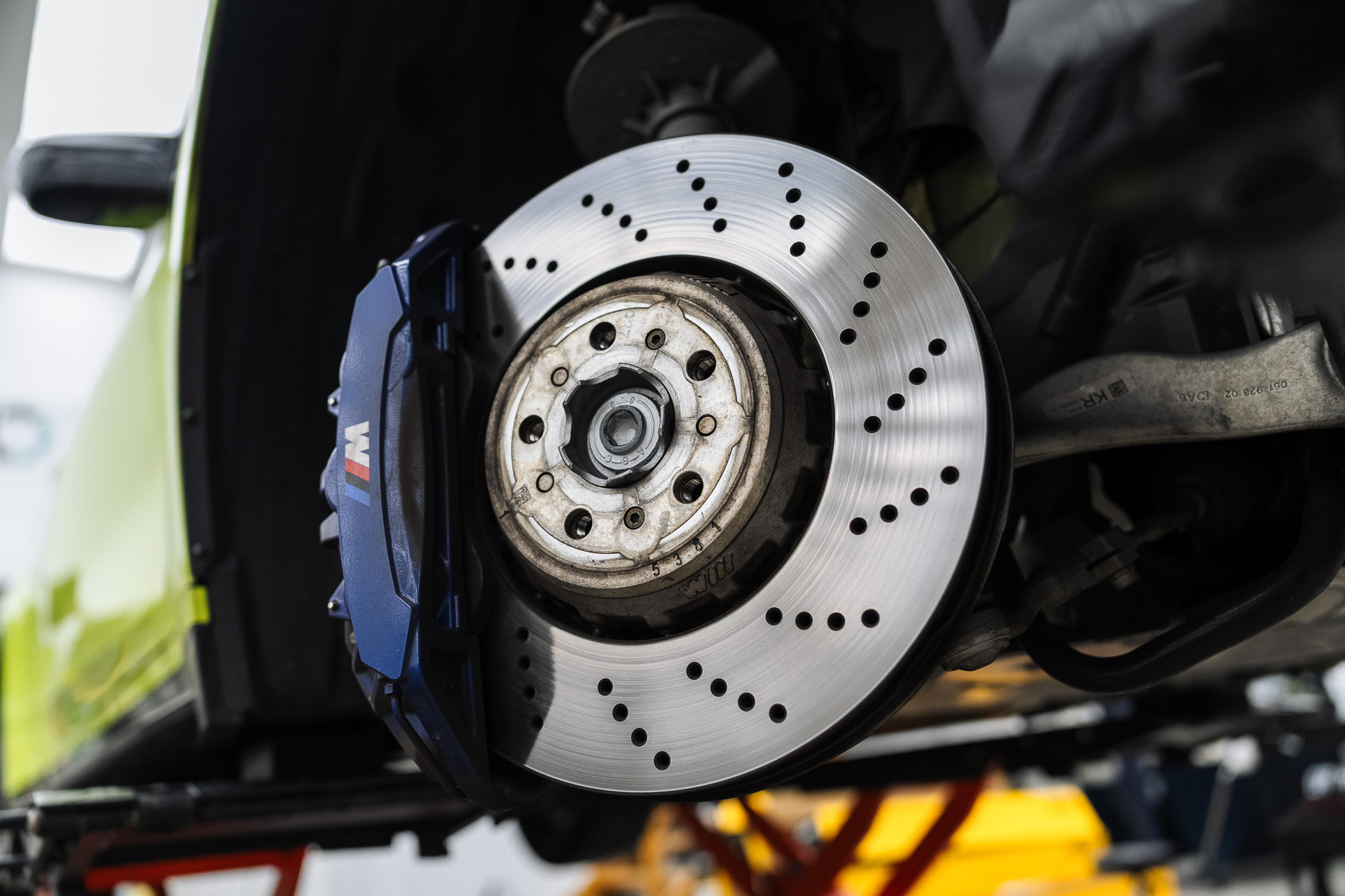 Drilled brake disc and blue caliper on a lifted car