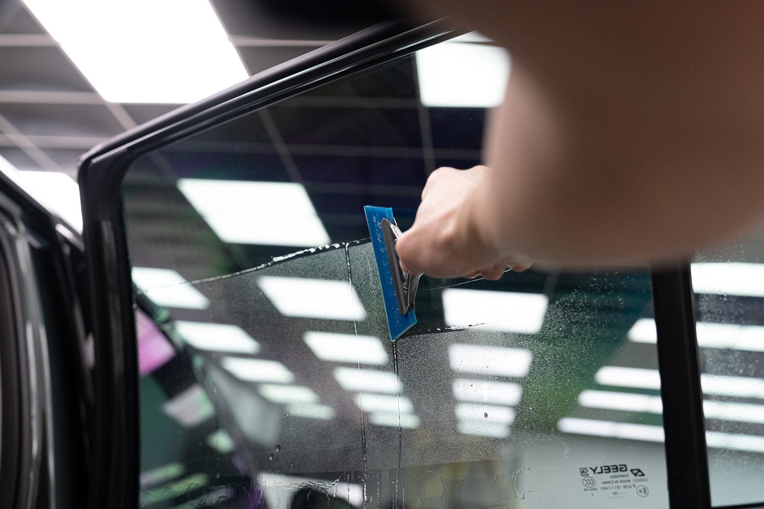 Squeegee fitting tint film to a car window