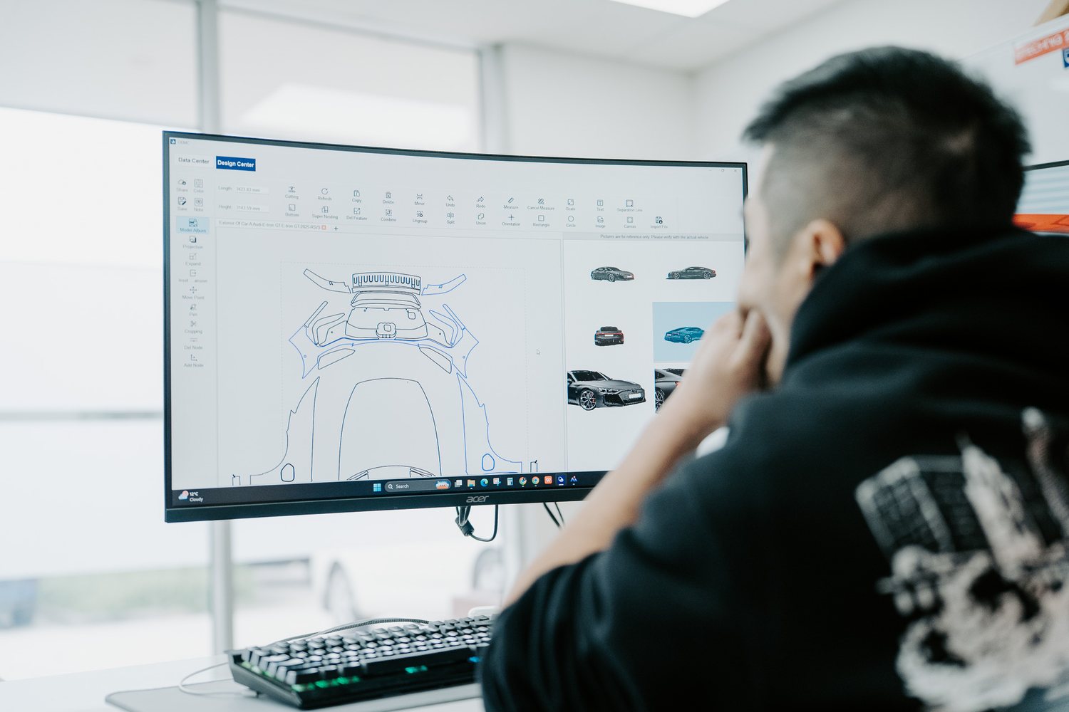 Technician plotting a precut paint protection film pattern on screen