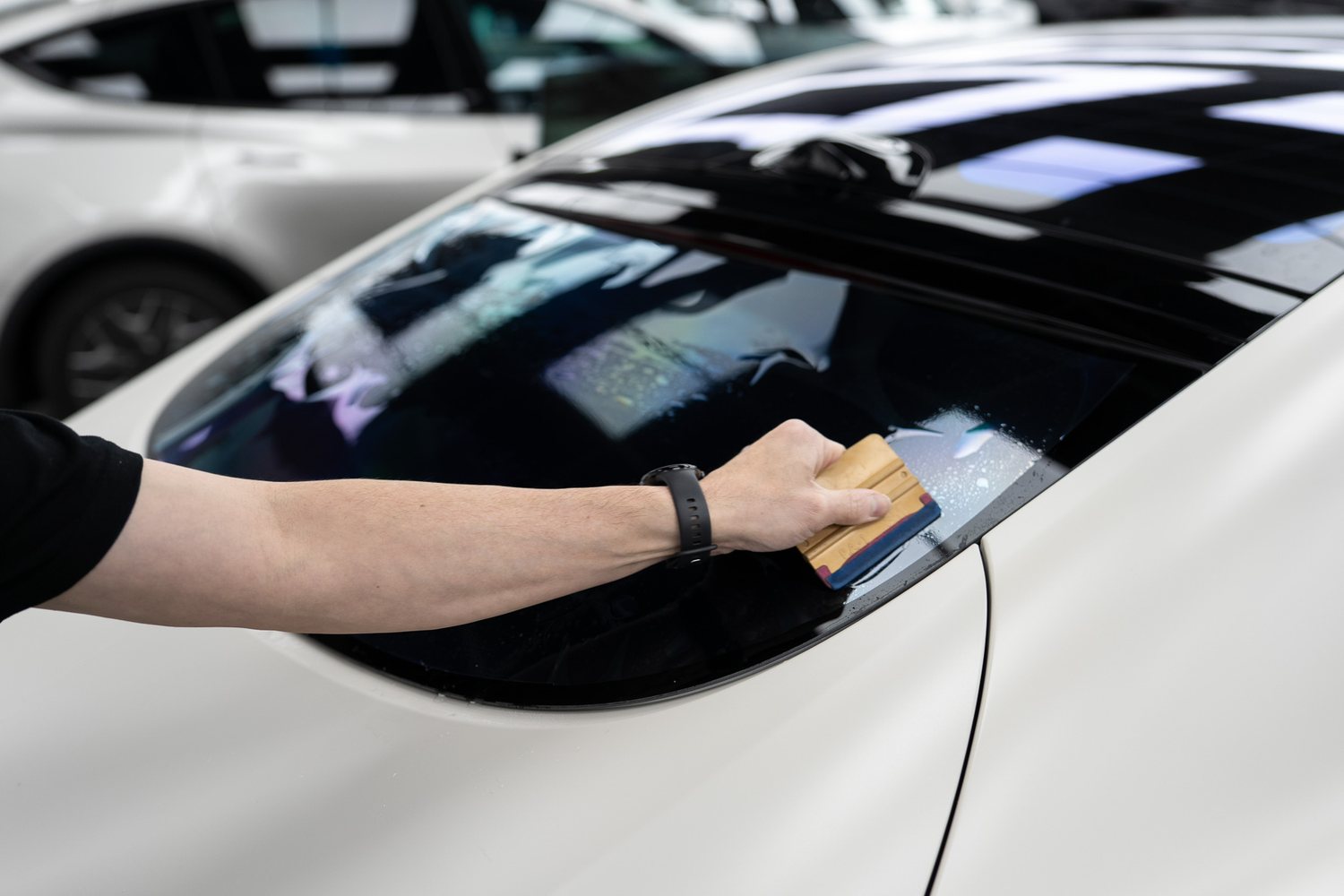 Technician wiping down the roof of a white car