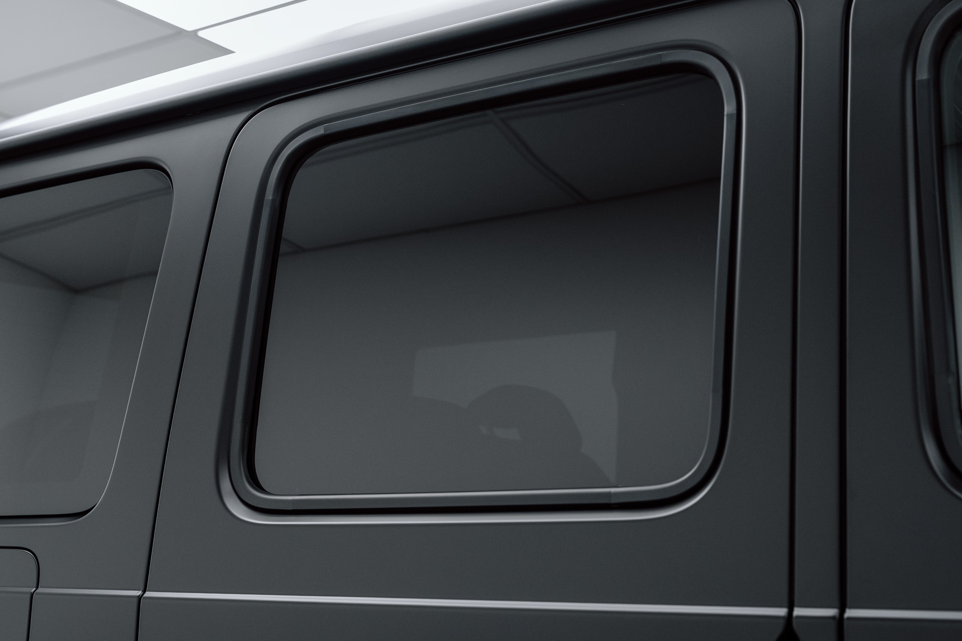 Dark tinted rear side window on a grey SUV
