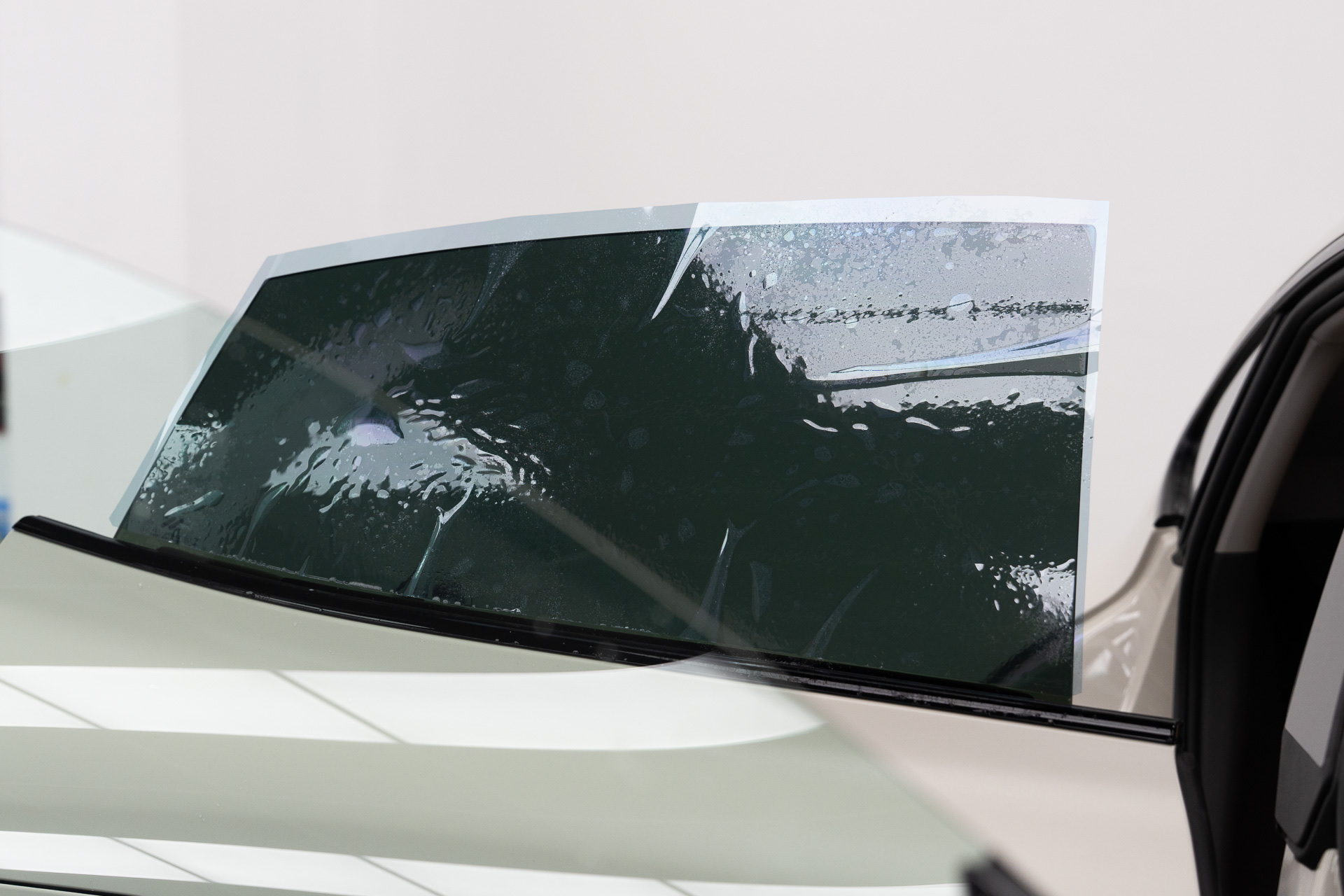 Window tint film being laid on a car window