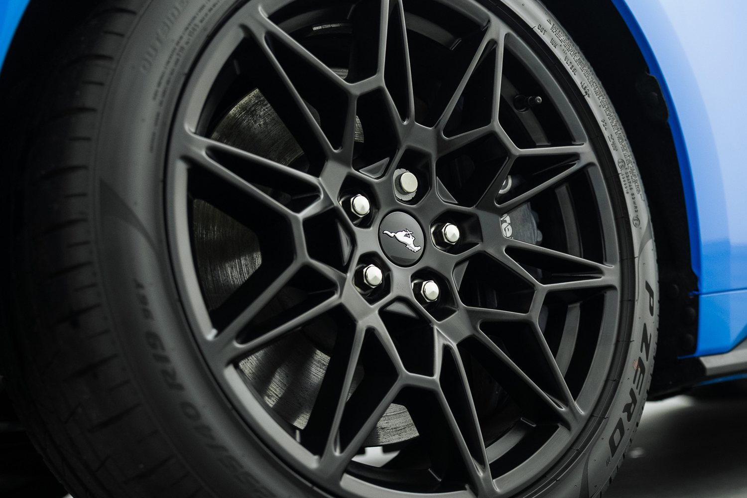 Wheel of a blue Ford Mustang