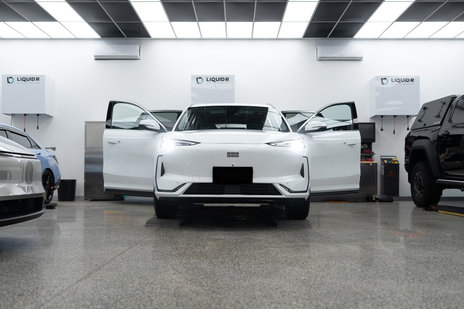 White SUV with doors open in the Liquid R workshop