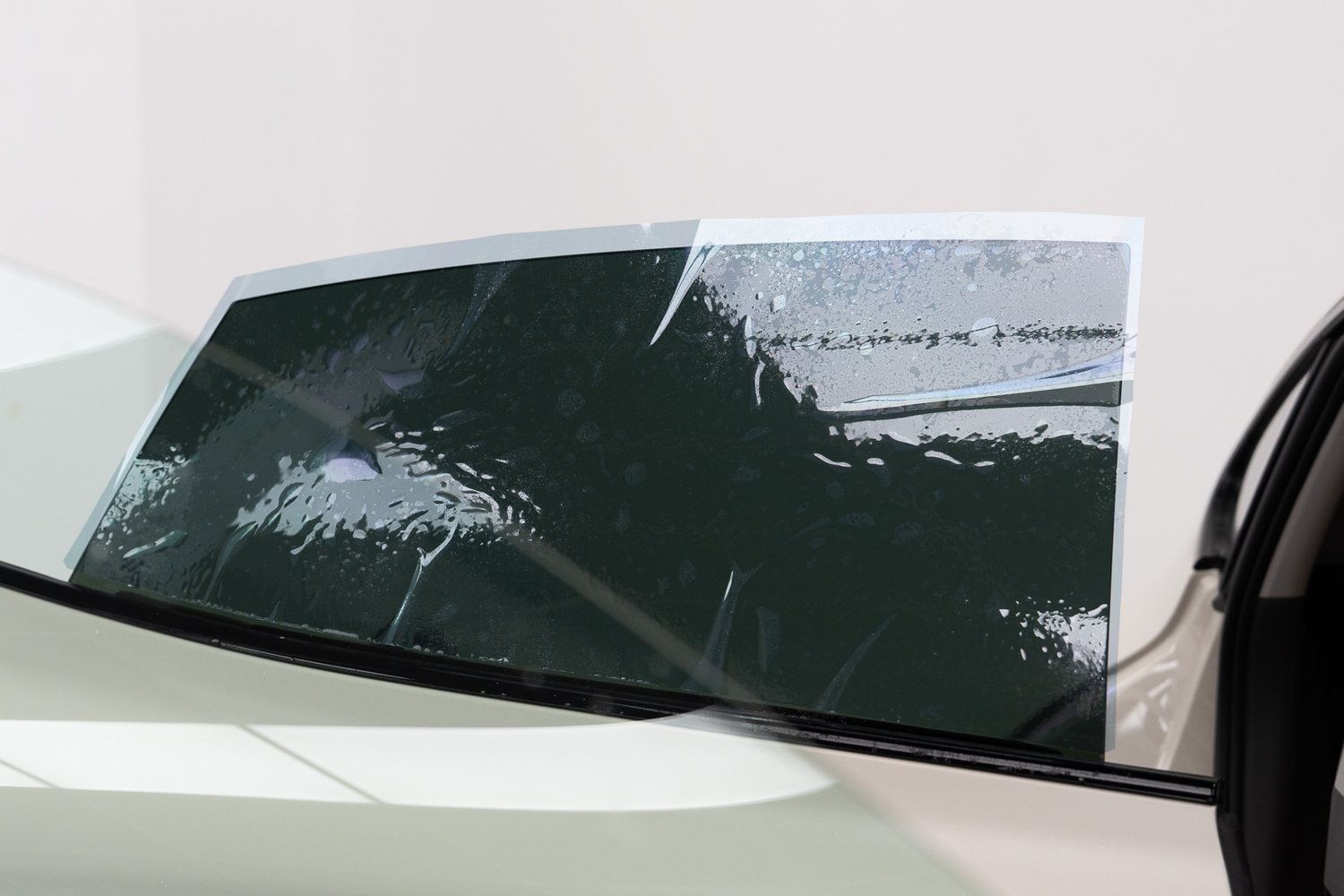 Window tint film being fitted to a car door