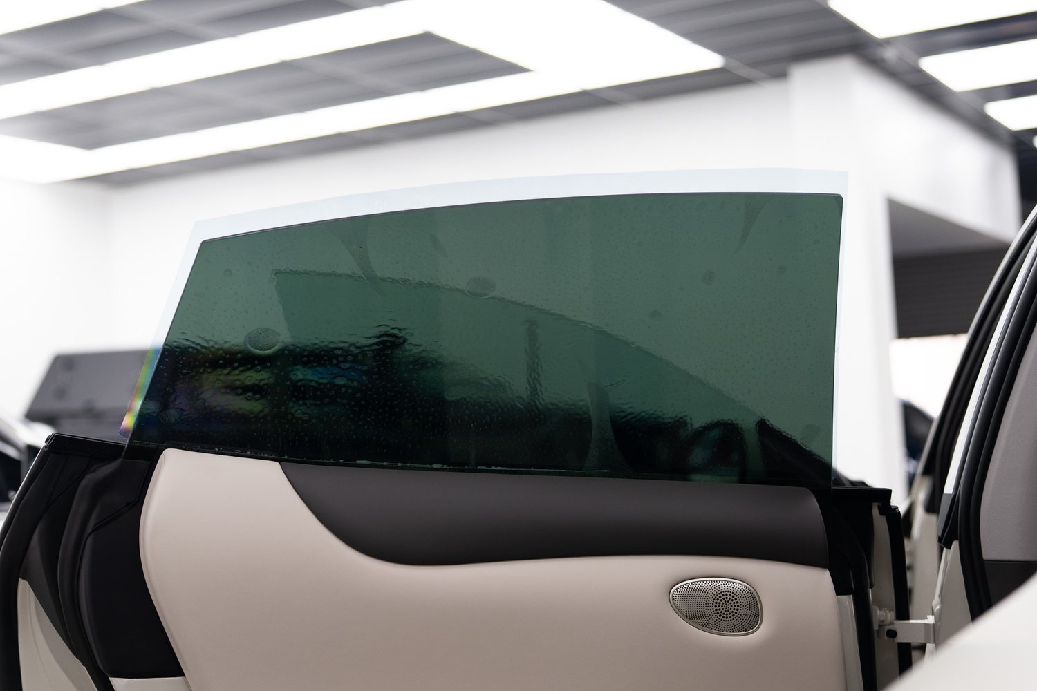 Window tint film being fitted to a car door